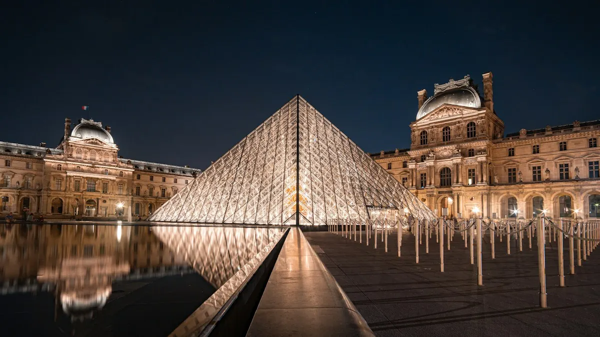 Pyramide de verre et façades du musée du Louvre éclairées la nuit à Paris